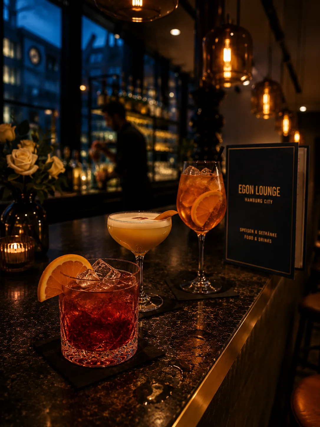 Drei Cocktails an der Egon-Lounge-Bar · Hendrik im Hintergrund