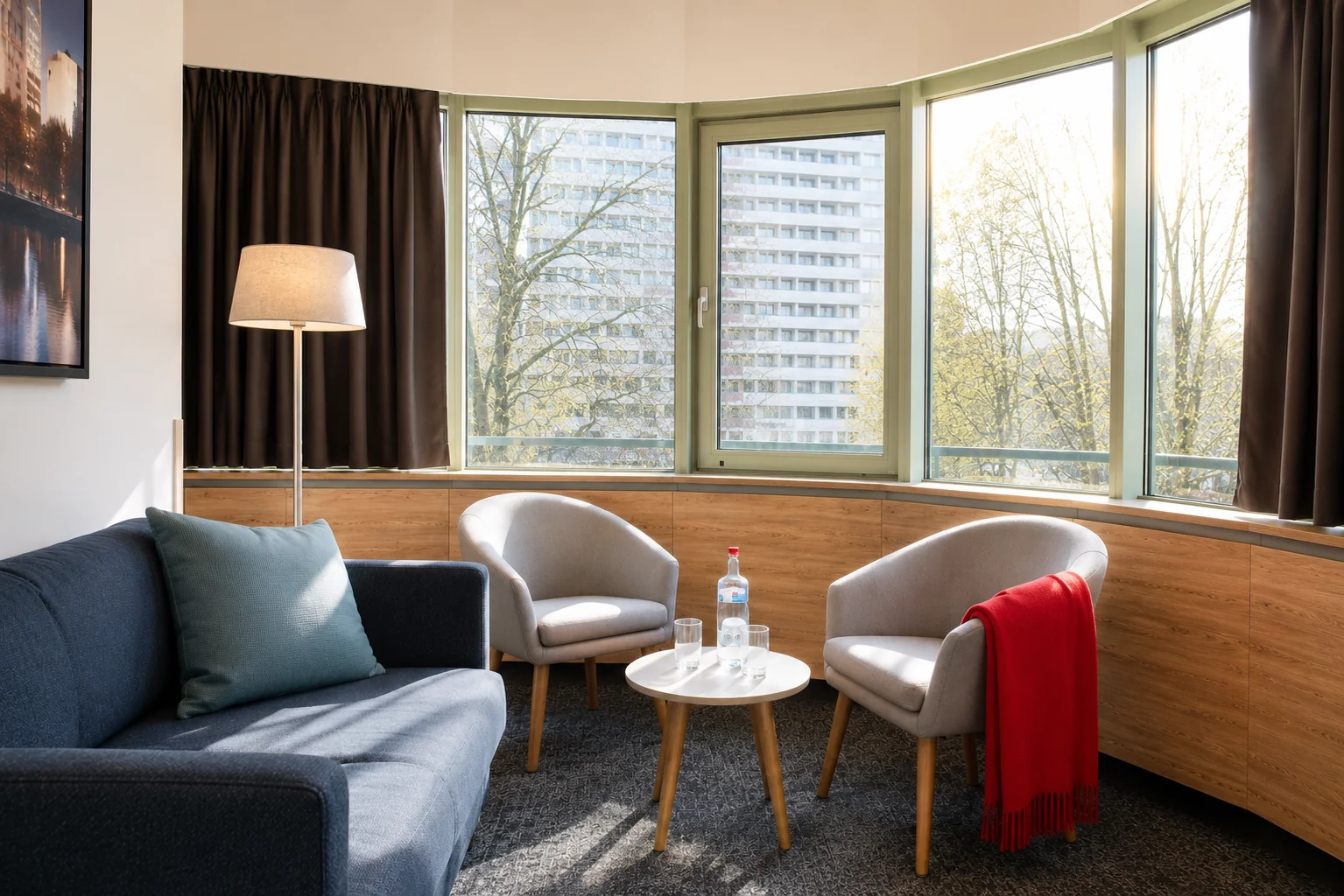 Sofa-Ecke des Panoramazimmers mit zwei Sesseln, Couchtisch und Bay-Window-Aussicht